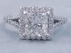 an engagement ring with a princess cut diamond surrounded by pave diamonds