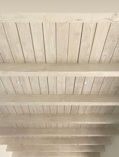 an empty room with wood planks on the ceiling