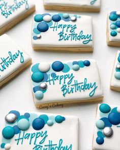 decorated cookies with blue and white icing are arranged on a table for a birthday party