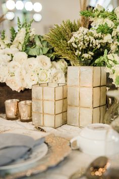 the table is set with white flowers and candles