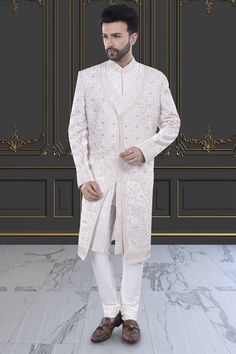 This two-layer sherwani features intricate stones and zardozi, making it perfect for a stylish groom. Step up your traditional attire game with this unique and elegant piece. Elegant Ceremonial Traditional Wear With Stone Work, Ceremonial Long Sherwani With Resham Embroidery, Elegant Long Nehru Jacket With Dabka Work, Eid Traditional Wear With Stone Work, Designer Traditional Wear With Naqshi Detailing, Designer Long Traditional Wear With Naqshi Detailing, Designer Long Traditional Wear With Naqshi, Formal Long Sherwani With Intricate Embroidery, Ceremonial Long Bandhgala With Intricate Embroidery