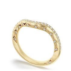 a yellow gold wedding band with diamonds on the sides and an intricate design in the middle