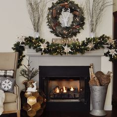 a living room decorated for christmas with wreaths on the mantle and fire in the fireplace