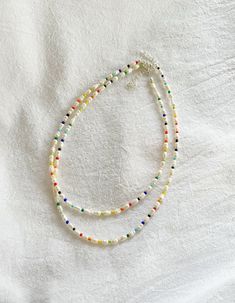 ∙ MINIMAL ∙ PEARL ∙ NECKLACE∙ Freshwater pearls are naturally unique in colour, shape, and texture so may differ slightly from those pictured.  ∙ APPROXIMATE ∙ MEASUREMENTS ∙ Each necklace comes with an additional 2 inch extension chain on top of your selected length.   For example, if you select the 14 inch necklace option, the total length of the necklace will be 16 inches including the clasp and extension chain. ∙ MATERIALS ∙  Strong steel cord, genuine freshwater pearls, coloured glass beads, silver plated or sterling silver clasp and extension chain. ∙ CARE ∙ INSTRUCTIONS ∙ The colour on silver plated or sterling silver jewellery may fade over time if it is not properly taken care of. To ensure it stays in perfect condition: 1. Remove before coming into contact with water (e.g. swimmi Freshwater Pearl Necklace Diy, Dainty Pearl Necklace With Colorful Beads, Handmade Adjustable Double Strand Pearl Necklace, Pearl Choker With Colorful Round Beads, Dainty Pearl Beaded Necklaces With Tiny Beads, Adjustable Multicolor Pearl Necklace With Tiny Beads, Multicolor Adjustable Pearl Necklace With Tiny Beads, Multicolor Pearl Necklace With Tiny Beads And Adjustable Fit, Handmade Multi-strand Pearl Beaded Necklaces