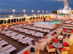 an outdoor seating area on the deck of a cruise ship at night with bright lights