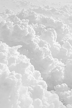 black and white photograph of clouds in the sky from an airplane window, looking down