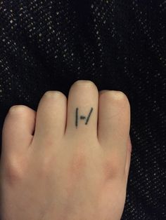 a person's hand with a small tattoo on their left thumb and the word love written in cursive writing