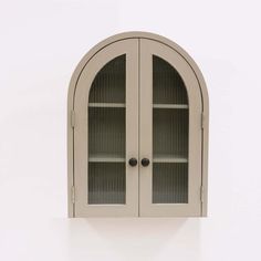 an arched glass cabinet with two doors on the front and one door in the back