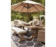 an outdoor dining table with chairs and umbrella