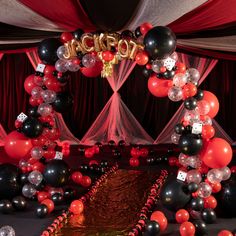 an arch made out of black, white and red balloons with the word acrobat on it