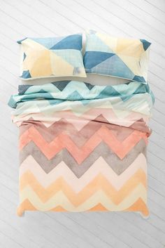 a stack of pillows sitting on top of a bed