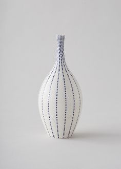 a white and blue vase sitting on top of a table