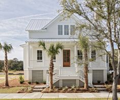 a white house with palm trees in the front yard