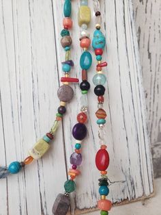 "Three stunning graduated strands of multi color, semi precious stones make up this long bold necklace. Just about every stone you can imagine; turquoise, garnet, lapis, pearl, chrysoprase, red coral, and carnelian, just to name a few. The stones are accented with Bali sterling silver fancy spacers. The longest strand measures 33\", the middle strand measures 30\" and the shortest strand measures 27\". All three strands are connected with a sterling silver lobster clasp. It is hand strung on a 4 Bohemian Long Necklace With Gemstone Beads, Multicolor Gemstone Beads Lariat Necklace, Multicolor Lariat Necklace With Gemstone Beads, Spiritual Multicolor Long Necklace, Hippie Multicolor Gemstone Bead Necklaces, Adjustable Multicolor Spiritual Long Necklace, Hippie Multicolor Gemstone Beads Necklace, Multicolor Gemstone Beaded Lariat Necklace, Multicolor Gemstone Beaded Necklace For Festival