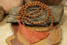 Rudraksha est probablement la première de toutes les perles à être utilisée dans les malas. Son histoire s'étend sur des millénaires et il est encore largement utilisé aujourd'hui. Les principales propriétés des perles et des malas de Rudraksha, documentées dans des textes anciens et expérimentées par la pratique, comprennent : * Purification et nettoyage du corps et de l'esprit *Protection * Santé et guérison * Concentration, Clarté et Focalisation de l'esprit * Équilibre émotionnel * Atténuer Rudraksha Mala, Knotted Mala, Rudraksha Beads, Mala Necklace, Spiritual Jewelry, Beaded Tassels, Prayer Beads, Natural Beads, Shades Of Red