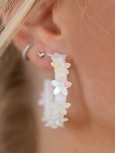 These earrings add a playful, summer inspired touch to any look. The thread wrapped hoop features floral details throughout the silhouette to add a bold touch to your summer look. Trendy Earrings For Spring, Summer Party 3d Flower Earrings, Small Hoop Earrings For Summer Beach, Spring Flower Earrings For Parties, Whimsical White Earrings For Spring, White Whimsical Spring Earrings, Whimsical White Spring Earrings, Small Hoop Earrings For Spring Beach Days, Small Hoop Earrings For Beach Spring Season