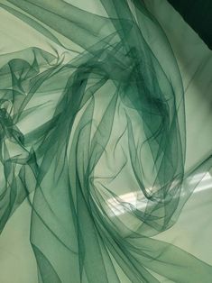 an abstract photograph of green sheer fabric