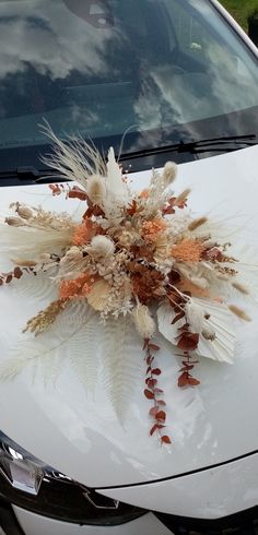 a car decorated with feathers and flowers on the hood