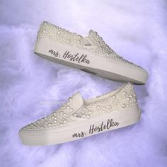 two white shoes with the words mrs herschel on them are laying on a fur surface