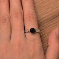 It is a natural black spinel ring. The main stone is 7mm*7mm round cut, weight about 1.65 carats. The basic metal is sterling silver and plated with rhodium. To change the metal to a solid gold (white/rose) or platinum is also available, please ask for a quotation if you want. You can also go to my shop Home for more elegant rings: https://www.etsy.com/shop/godjewelry?ref=hdr_shop_menu More black spinel rings: https://www.etsy.com/shop/godjewelry?ref=seller-platform-mcnav&section_id=21680005 Round Cut Solitaire Engagement Ring, Black Spinel Ring, Spinel Ring, Black Spinel, Elegant Ring, Round Cut, Womens Engagement Rings, Solitaire Ring, Solitaire Engagement Ring