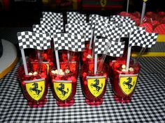 red glasses with black and white checkered flags are lined up on a tablecloth