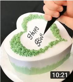 a person cutting into a heart shaped cake with the words happy birthday written on it