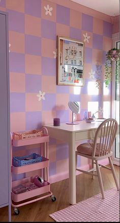 a pink and purple checkered wall in a girls'room with a white desk