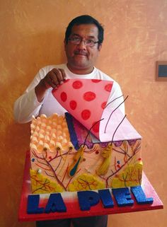 a man holding up a cake made to look like a house