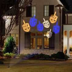 a house with some lights on it and decorations in front of the windows at night