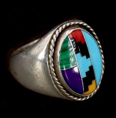 💎Signed-Charlie Yazzie, Vintage Navajo Multi Stone Inlay Ring Markings "C" hallmark for Charlie Yazzie *Inner ring has been personalized:                  "CONFIRMED 5-1-94 SWS" Tested as Sterling Silver Verified Sleeping Beauty Turquoise, Onyx, Malachite, Sugalite, Red Coral, "Yellow Turquoise"/Serpentine  Size 9 US Total Weight ~ 16.5 grams Band Width ~ 4 - 22mm Ornament/Setting Dimensions ~ 15 - 20mm  Made in the USA  Handmade Hand tooled Aboriginal Native American  Indigenous  Collectible Multicolor Polished Round Jewelry, Multicolor Round Jewelry With Polished Finish, Handmade Multicolor Artisan Turquoise Ring, Handmade Artisan Multicolor Turquoise Ring, Southwestern Style Hallmarked Round Jewelry, Traditional Sterling Silver Rings With Inlay, Multicolor Collectible Ring Jewelry, Unique Multicolor Rings With Polished Finish, Multicolor Polished Ring Jewelry