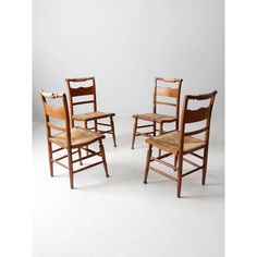 three wooden chairs sitting next to each other on a white surface with no one in it