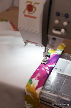 the sewing machine is working on the colorful tie - dye fabric that has been sewn