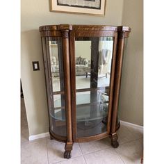 a wooden corner cabinet with glass doors in a living room