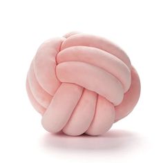 a pink ball of yarn sitting on top of a white surface with no one around it