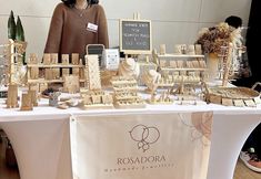 a woman standing in front of a table covered with wooden blocks and pieces of wood