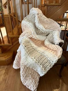 a pile of blankets sitting on top of a wooden floor next to a stair case