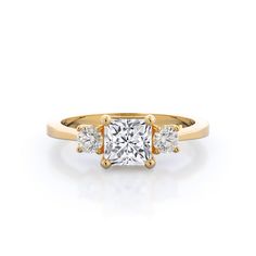 an engagement ring with three stones in the center and two diamonds at the bottom, on a white background