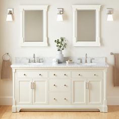 a bathroom with two sinks and mirrors on the wall