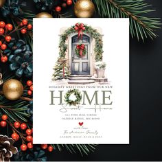 a holiday card with the words home on it, surrounded by christmas decorations and pine cones