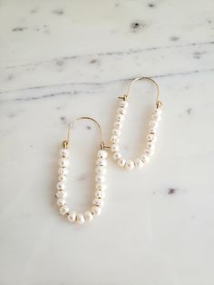 ∙These pearl hoop earrings are super femme and perfect for dressing up a simple outfit! Would also be wonderful for a bride with a bit of vintage flair. ∙Unique shape is sure to catch you some compliments. ∙Nice and lightweight on the ear! ∙Top quality materials are excellent for sensitive ears/skin. ∙These measure ~2.25 inches long. ~M A T E R I A L S ~ Choose from- * 925 Sterling silver *14k Gold fill *14k Rose gold fill **What is 14k Gold-fill?** Gold fill does not tarnish or wear off and con Delicate White Hoop Earrings With Pearl Drop, Chic 14k Gold Filled Jewelry For Wedding, Chic 14k Gold-filled Jewelry For Wedding, 14k Gold Filled Pearl White Wedding Earrings, White Pearl Embellished Hoop Earrings For Wedding, White 14k Gold Filled Bridal Earrings For Wedding, Wedding Hoop Earrings In Pearl White, Wedding Pearl White 14k Gold Filled Pearl Earrings, Delicate Hoop Pearl Earrings For Wedding