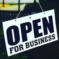 an open for business sign hanging from a window