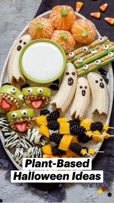 an assortment of halloween treats on a platter with candy eyes, bananas and oranges