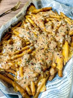 french fries covered in gravy on top of a newspaper