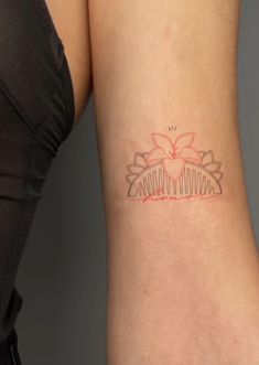 a woman's arm with a tattoo on the back of her left arm and an orange flower