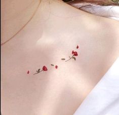 a woman's chest with three small roses on the left side of her breast