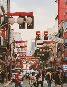 people crossing the street at an intersection with traffic lights