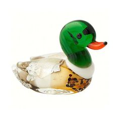 a green rubber duck sitting on top of a glass bowl