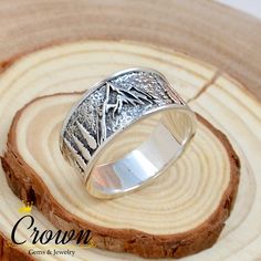 a silver ring sitting on top of a piece of wood