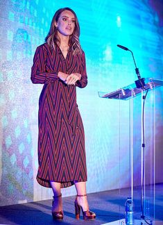 a woman standing at a podium in front of a microphone