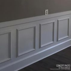 an empty room with white paneling on the wall